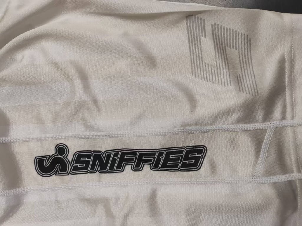 Close-up of side text logo on white sports shorts fabric
