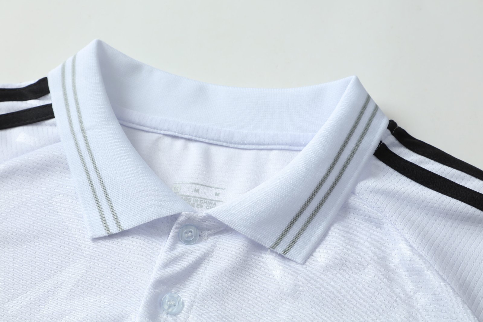 Close-up factory photo of thai-quality polo collar White soccer uniform set by professional wholesale soccer jerseys