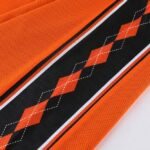 Close-up of orange black argyle pattern on reversible basketball shorts fabric
