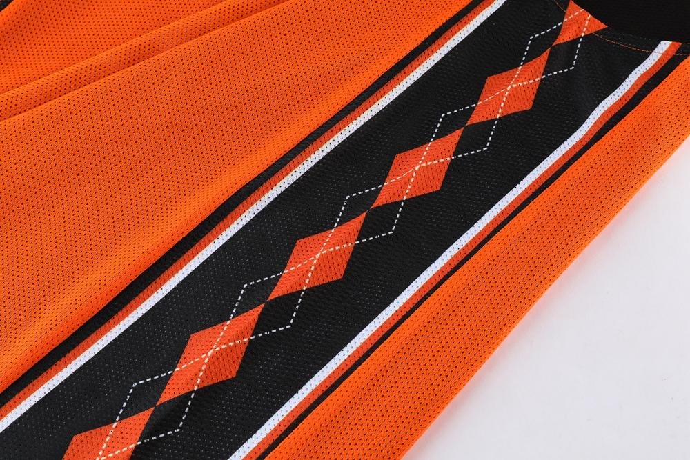 Close-up of orange black argyle pattern on reversible basketball shorts fabric