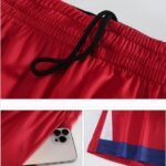 Red basketball shorts with drawstring, side pocket and size demonstration