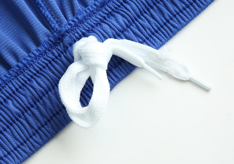 White drawstring detail on blue soccer shorts waistband