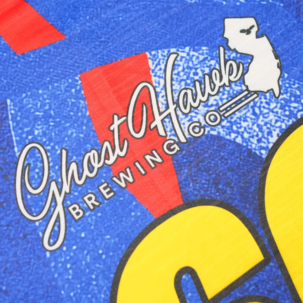 Close-up of Ghost Hawk Brewing Co logo on blue sublimation jersey