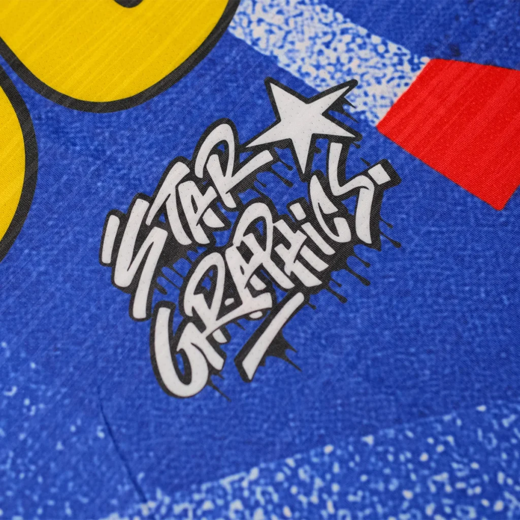 Star Graphics graffiti style logo close-up on blue soccer jersey