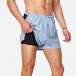 Male model displaying custom 2-in-1 running shorts with a built-in black compression liner, perfect for wholesale activewear brands seeking functional designs.