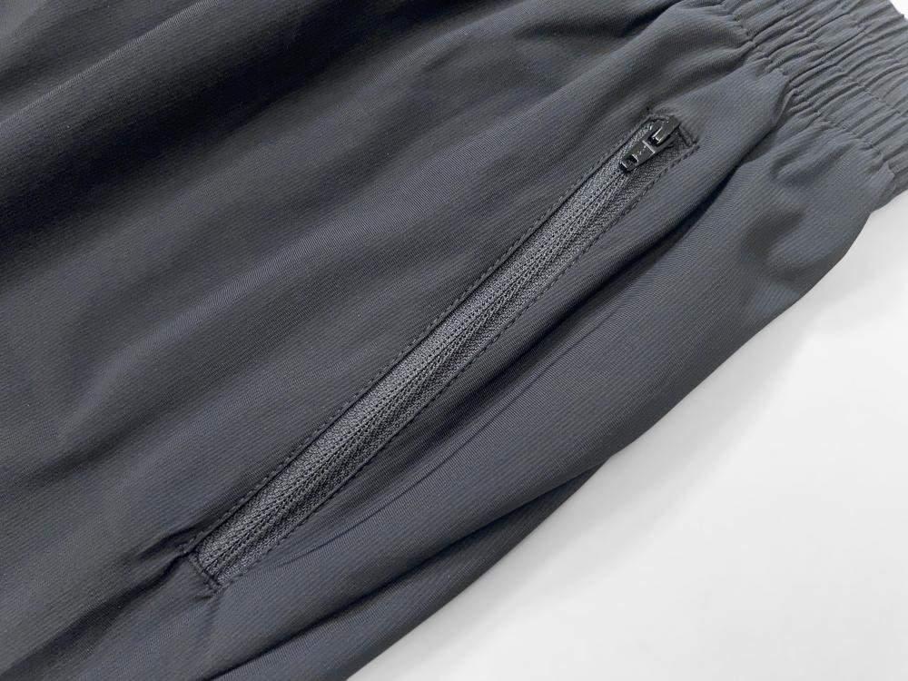 Close-up of custom men's running shorts featuring a wide elastic waistband and secure zipper pockets, ideal for bulk wholesale sportswear orders.
