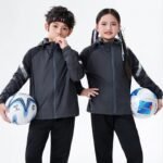 er-boy-girl-with-football.webpBoy and girl wearing dark grey hooded soccer windbreakers holding footballs