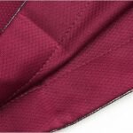 Close-up of maroon mesh fabric and stitching on basketball shorts