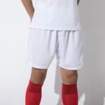 Man wearing white soccer shorts with red socks and white jersey