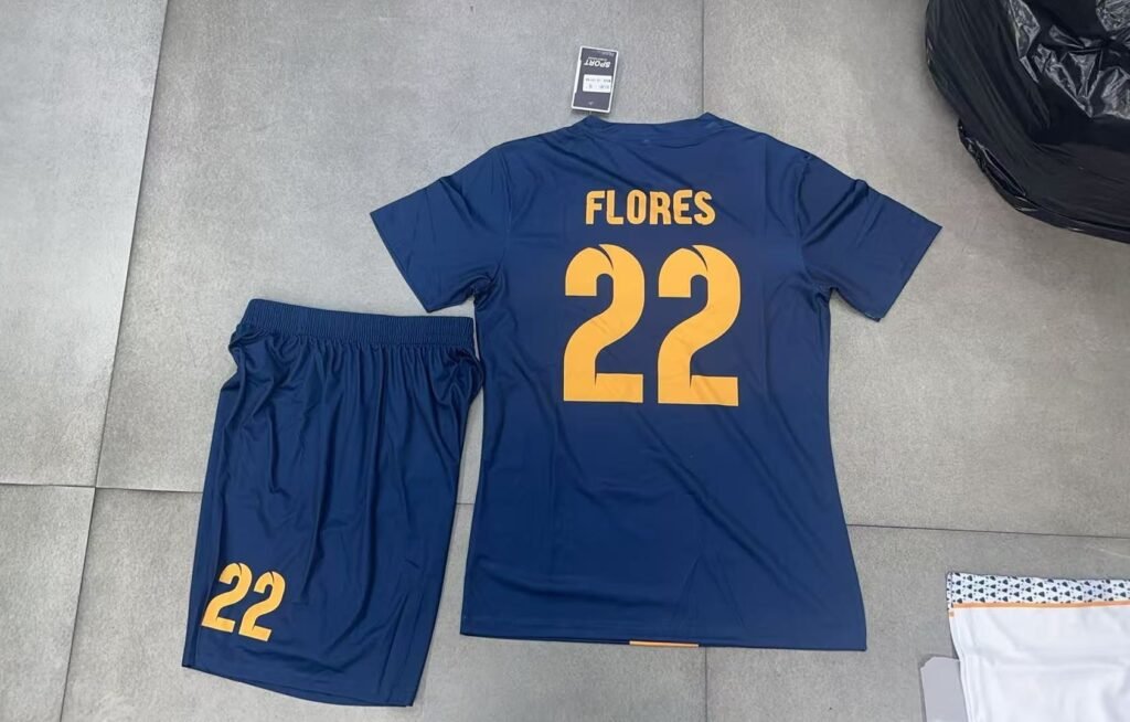 B2B custom navy blue soccer kit back view, featuring heat transfer player name FLORES and number 22, perfect for personalized small batch sportswear.