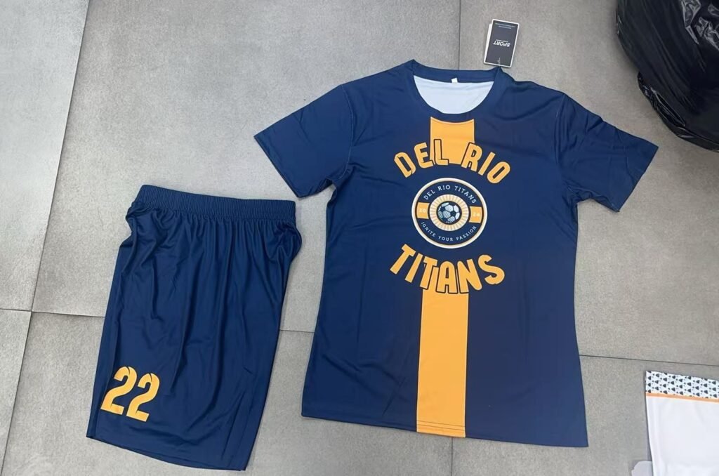 Wholesale custom navy blue and yellow horizontal stripe soccer uniform front view, featuring heat transfer team badge and sponsor logo for small batch OEM.