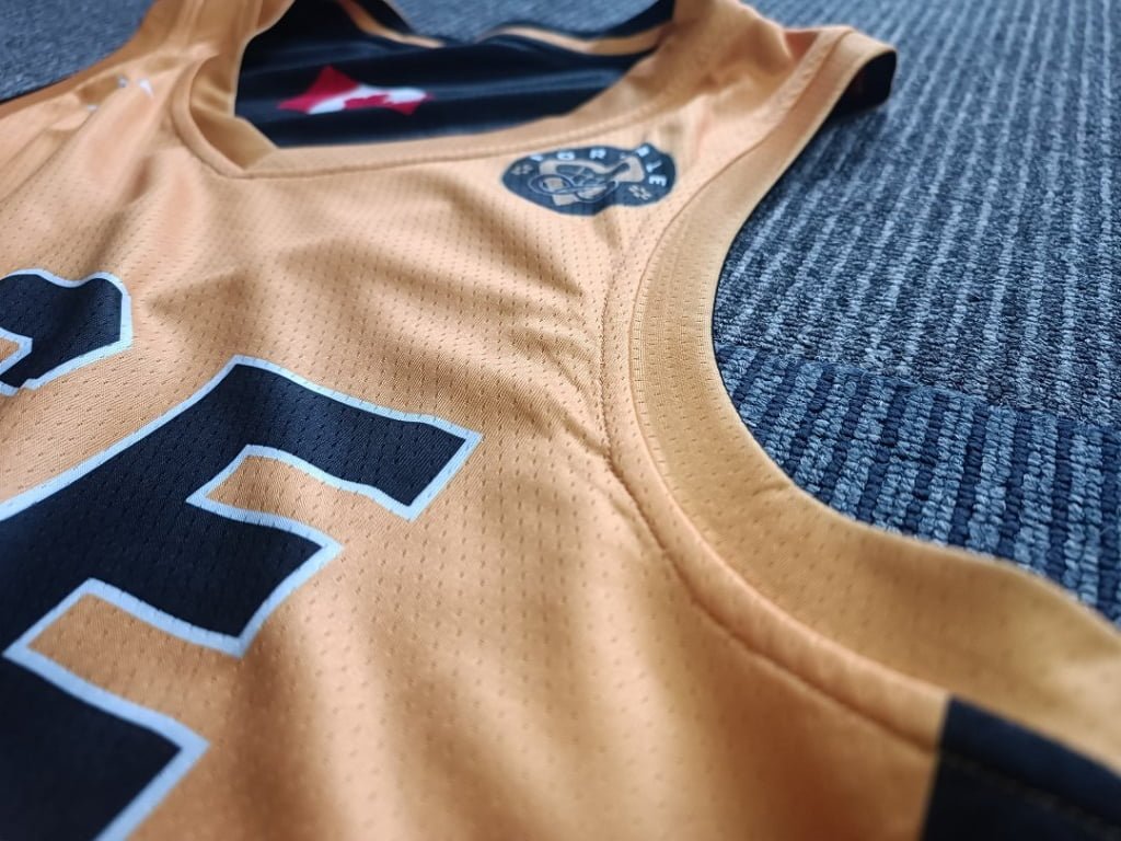 Close-up of yellow reversible basketball jersey neckline and mesh fabric detail