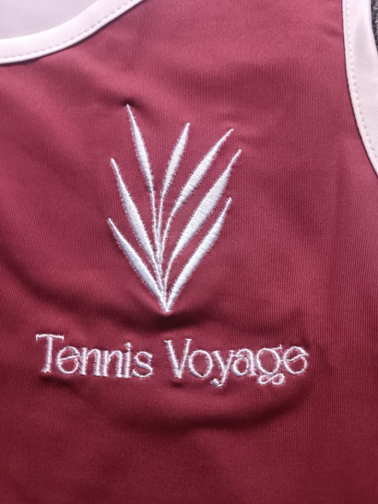 Close-up of premium white thread embroidery showing precise stitch quality on athletic fabric.